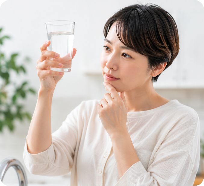 コップの水を見つめる女性
