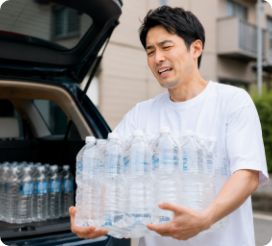 ペットボトルを運ぶ男性